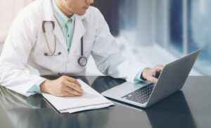 doctor-on-desk-with-table-cropped_613913759-1200