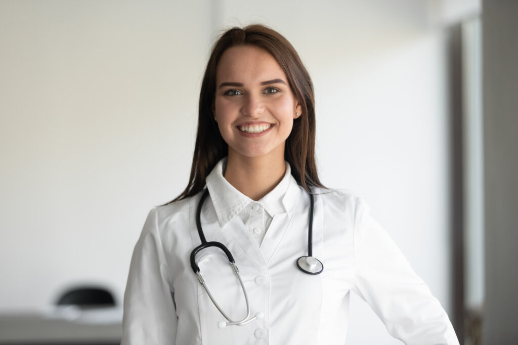 Portrait of smiling female doctor posing wearing whites