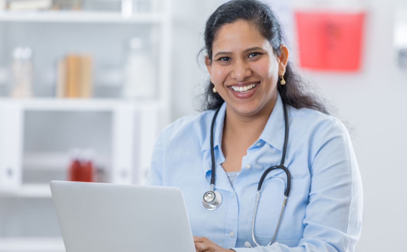 A female doctor at a laptop computer. Protect your medical career with Own Occupation disability insurance for doctors.